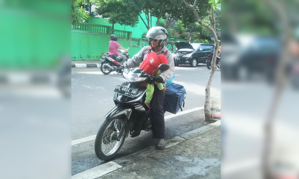 Loper Koran Sambil Gendong Anak di Bali