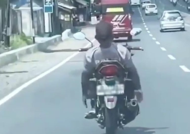 Pria Berkaos Polisi Lakukan Atraksi Rebahan di Atas Motor